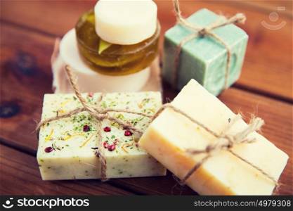 beauty, spa, body care, bath and natural cosmetics concept - close up of handmade soap bars on wooden table. close up of handmade soap bars on wood