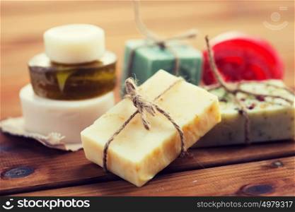 beauty, spa, body care, bath and natural cosmetics concept - close up of handmade soap bars on wooden table. close up of handmade soap bars on wood