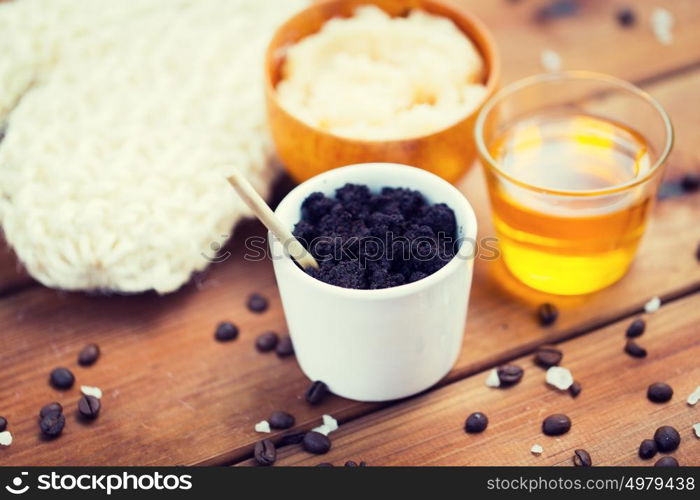 beauty, spa, body care, bath and natural cosmetics concept - close up of coffee scrub in cup and honey on wooden table. close up of coffee scrub in cup and honey on wood