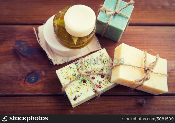 beauty, spa, body care, bath and natural cosmetics concept - close up of handmade soap bars on wooden table. close up of handmade soap bars on wood