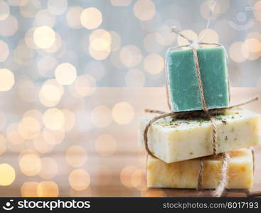 beauty, spa, body care, bath and natural cosmetics concept - close up of handmade soap bars on wooden table