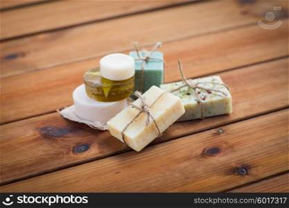 beauty, spa, body care, bath and natural cosmetics concept - close up of handmade soap bars on wooden table