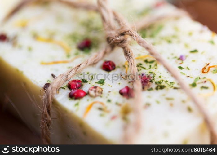 beauty, spa, body care, bath and natural cosmetics concept - close up of handmade soap bars on wooden table