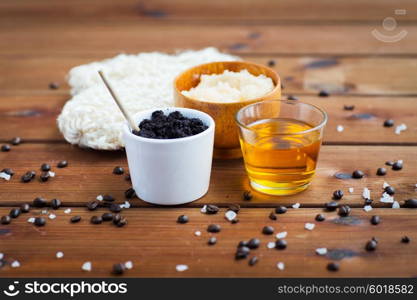 beauty, spa, body care, bath and natural cosmetics concept - close up of coffee scrub in cup and honey on wooden table