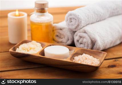beauty, spa, body care, natural cosmetics and bath concept - close up of soap natural cosmeticshimalayan salt and scrub in wooden bowl on table