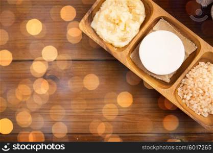 beauty, spa, body care, natural cosmetics and wellness concept - close up of soap with himalayan pink salt and scrub in wooden bowl on table