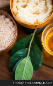 beauty, spa, body care, natural cosmetics and wellness concept - close up of body scrub in wooden bowl