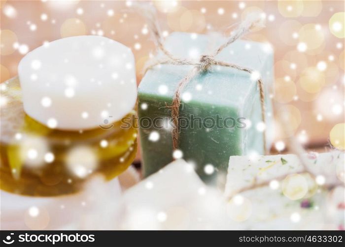beauty, spa, bodycare, bath and natural cosmetics concept - close up of handmade soap bars over snow
