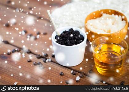 beauty, spa, bodycare, bath and natural cosmetics concept - coffee scrub in cup and honey on wooden table over snow