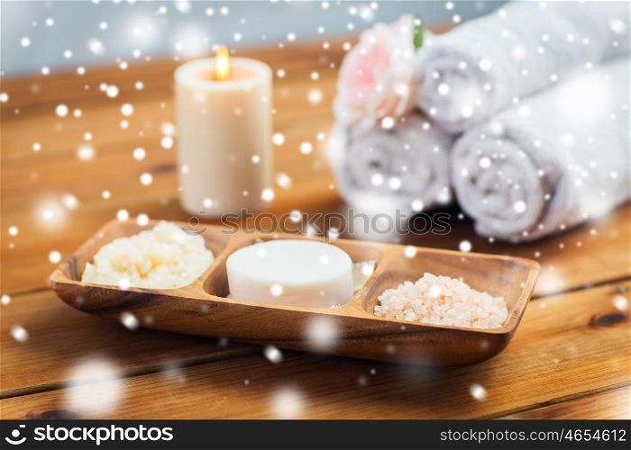 beauty, spa, bodycare, natural cosmetics and bath concept - soap natural cosmetics himalayan salt and scrub in wooden bowl on table over snow