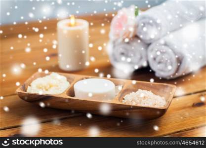 beauty, spa, bodycare, natural cosmetics and bath concept - soap natural cosmetics himalayan salt and scrub in wooden bowl on table over snow
