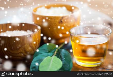 beauty, spa, bodycare, natural cosmetics and wellness concept - close up of honey in glass with leaves on wood over snow