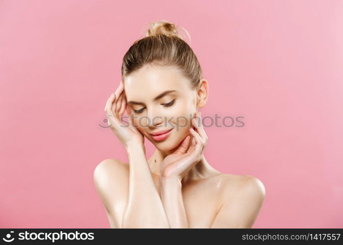 Beauty Spa Concept - Caucasian Woman with perfect face skin Portrait. Beautiful Brunette Spa Girl showing empty copy space. Isolated on pink studio background. Proposing a product. Beauty Spa Concept - Caucasian Woman with perfect face skin Portrait. Beautiful Brunette Spa Girl showing empty copy space. Isolated on pink studio background. Proposing a product.
