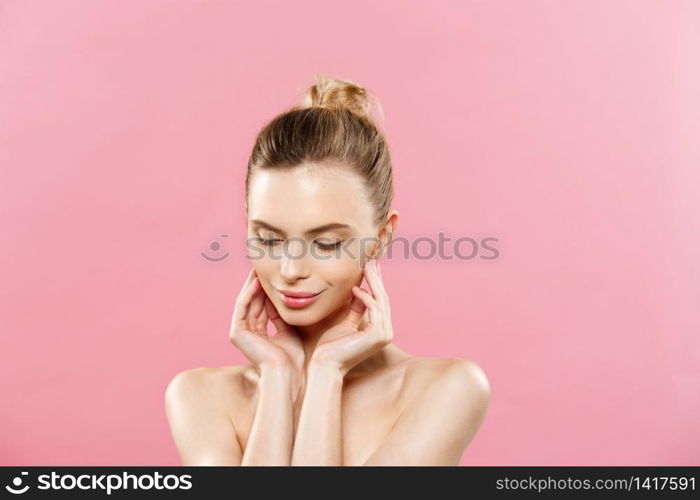 Beauty Spa Concept - Caucasian Woman with perfect face skin Portrait. Beautiful Brunette Spa Girl showing empty copy space. Isolated on pink studio background. Proposing a product. Beauty Spa Concept - Caucasian Woman with perfect face skin Portrait. Beautiful Brunette Spa Girl showing empty copy space. Isolated on pink studio background. Proposing a product.