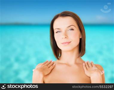 beauty, spa, health and people concept - beautiful woman touching her shoulders