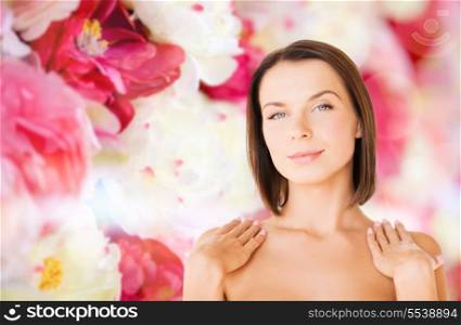 beauty, spa, health and people concept - beautiful woman touching her shoulders