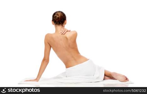 beauty, spa, people and bodycare concept - beautiful young woman in white towel with bare top. beautiful young woman in white towel with bare top