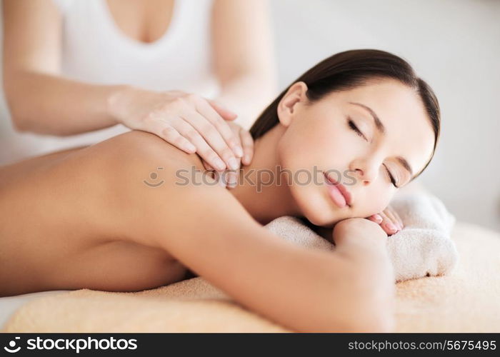 beauty, spa, resort and relaxation concept - beautiful woman in spa salon getting massage