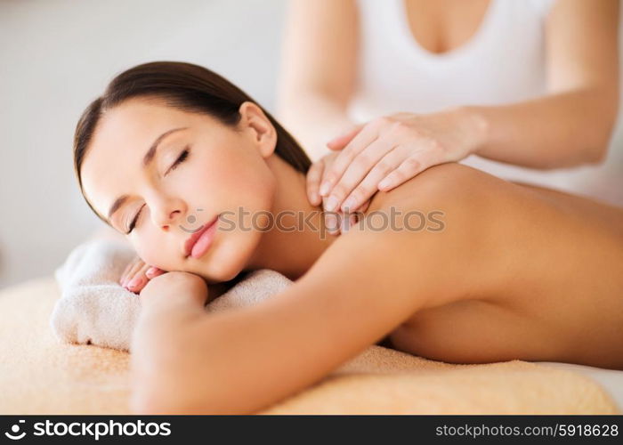 beauty, spa, resort and relaxation concept - beautiful woman in spa salon getting massage