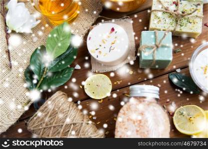 beauty, spa, therapy and wellness concept - natural body care cosmetics on wood over snow
