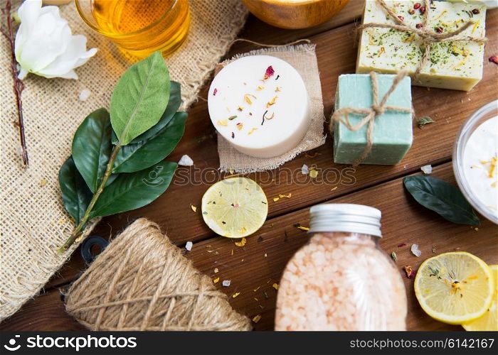 beauty, spa, therapy, natural cosmetics and wellness concept - close up of body care cosmetic products on wood