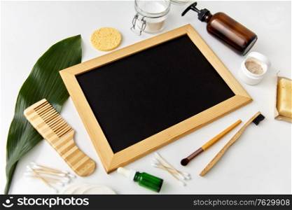 beauty, sustainability and eco living concept - natural cosmetics, bodycare eco products and chalkboard on white background. natural cosmetics and chalkboard