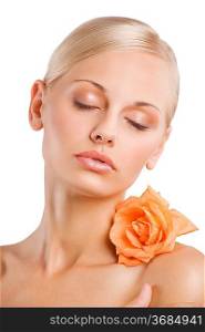 beauty sweet portrait of a blond pretty woman with an orange wet flower on shoulder relaxing with closed eyes