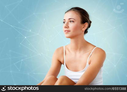 beauty, technology and people concept - beautiful happy young woman over low poly shape projection on blue background. beautiful happy young woman at home. beautiful happy young woman at home