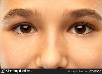 beauty, vision and people concept - close up of teenage girl face with brown eyes. close up of teenage girl face with brown eyes