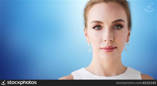 beauty, wedding and people concept - face of beautiful woman or bride in white dress over blue background