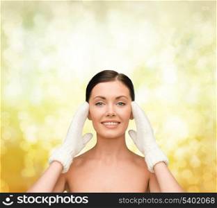 beauty, winter, spa and health concept - smiling young woman in white mittens