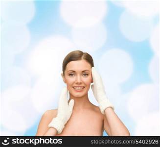 beauty, winter, spa and health concept - smiling young woman in white mittens