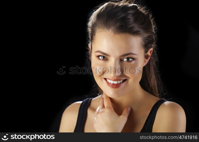 Beauty woman face closeup isolated on black background. Beautiful model girl makeup. Gorgeous sexy brunette lady touching her skin. Perfect make up