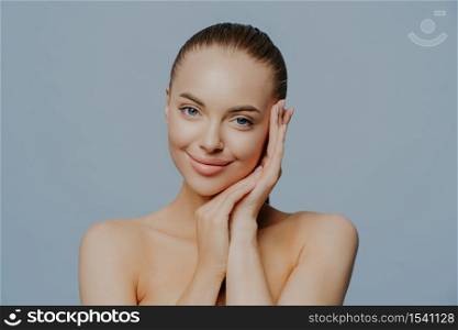 Beauty woman face portrait. Beautiful spa model girl with perfect fresh clean skin on blue background. Brunette female looking at camera. Youth and skin care concept.