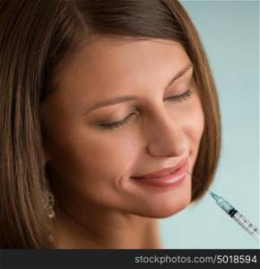 Beauty Woman face with syringe on her lips