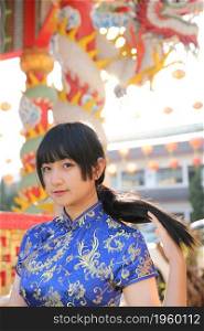 beauty woman wear blue cheongsam looking and smile in chinese new year