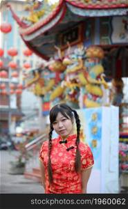 beauty woman wear red cheongsam looking and smile in chinese new year