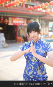 beauty woman wear red cheongsam looking and smile in chinese new year