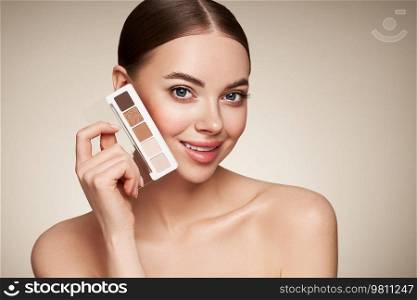 Beauty woman with eye shadow makeup palette. Model with healthy perfect skin, close up portrait. Cosmetology, beauty and spa
