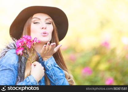 Beauty woman with flowers. Freedom and leisure. Gorgeous adorable woman holding pink flowers. Romantic portrait of beautiful young lady blowing kiss.