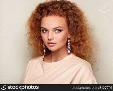 Beauty woman with long and shiny curly hair. Perfect make-up. Beauty style model with jewelry. Fashion photo