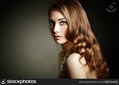 Beauty woman with long curly hair. Beautiful girl with elegant hairstyle. Fashion photo