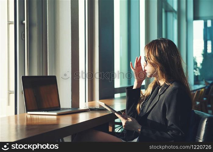 beauty working women black suit clothe brown long hair sunglasses use tablet and computer laptop sitting on chair at her office