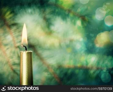 Beauty Xmas backgrounds with golden candle against fir tree and bokeh