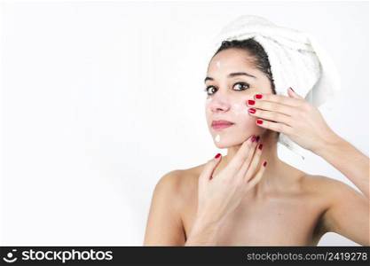 beauty young woman applying cream face isolated white backdrop