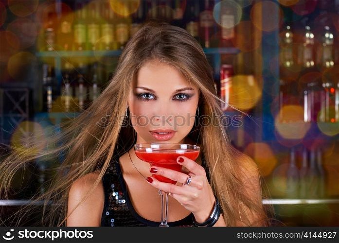 Beauty young woman portrait with a glass drinking a cocktail at a bar