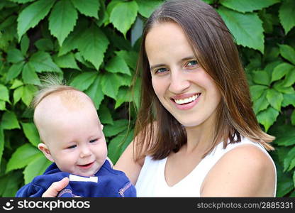 Beauty young woman with her baby outdoors