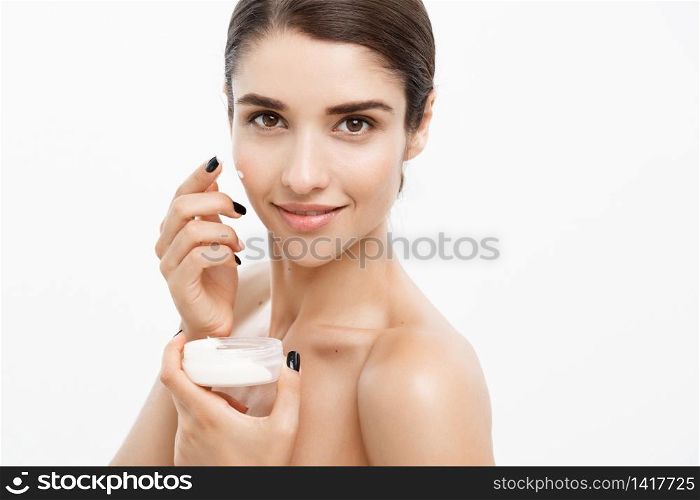 Beauty Youth Skin Care Concept - Close up Beautiful Caucasian Woman Face Portrait applying some cream to her face. Beautiful Spa model Girl with Perfect Fresh Clean Skin over white background. Beauty Youth Skin Care Concept - Close up Beautiful Caucasian Woman Face Portrait applying some cream to her face. Beautiful Spa model Girl with Perfect Fresh Clean Skin over white background.
