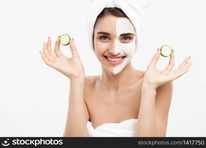 Beauty Youth Skin Care Concept - Portrait Beautiful Caucasian Woman apply cream and holding fresh cucumber in front of her face.Isolated over white background. Beauty Youth Skin Care Concept - Portrait Beautiful Caucasian Woman apply cream and holding fresh cucumber in front of her face.Isolated over white background.
