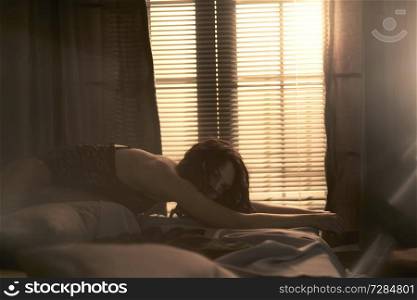 Beautyful nude woman in home interior. Sexy lady with perfect body in bedroom. Sexual portrait of young model pose infront of windows. Erotic figure of naked beauty in room. 